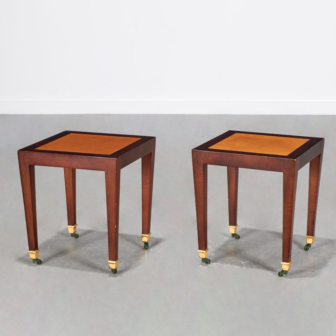 John Hutton for Donghia, pair "Madrid" side tables: John Hutton for Donghia, pair "Madrid" side tables, Late 20th c., dark wood frame with lighter inset, raised on tapered legs, with casters, marked underside, 17.5"h x 15"squ Provenance: A Private Coll