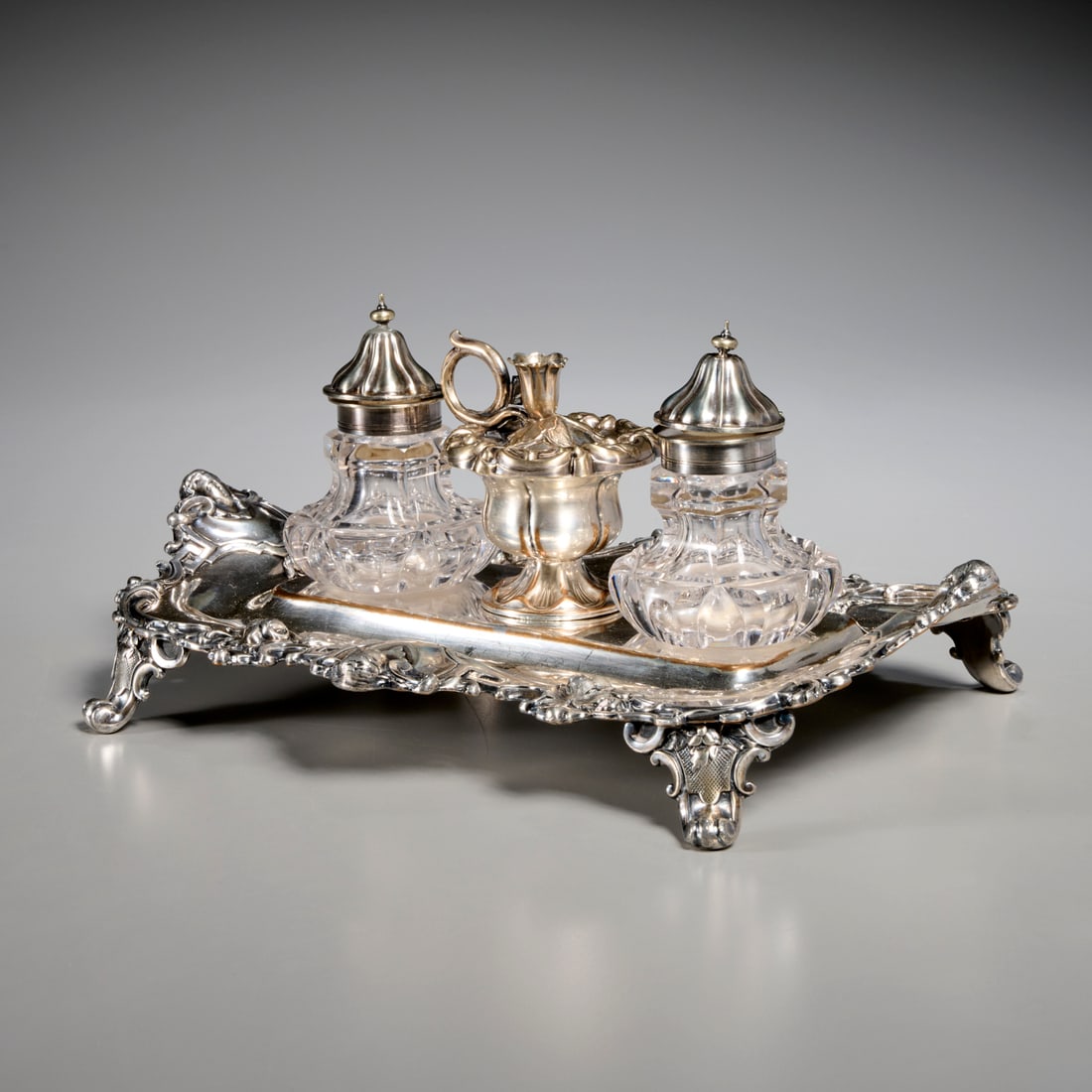 Victorian silverplate and glass ink stand: Victorian silverplate and glass ink stand, Late 19th c., with mask head mounts, unmarked, 6"h x 12"l x 9"w Provenance: A Private Collection: 1095 Park Avenue, NYC