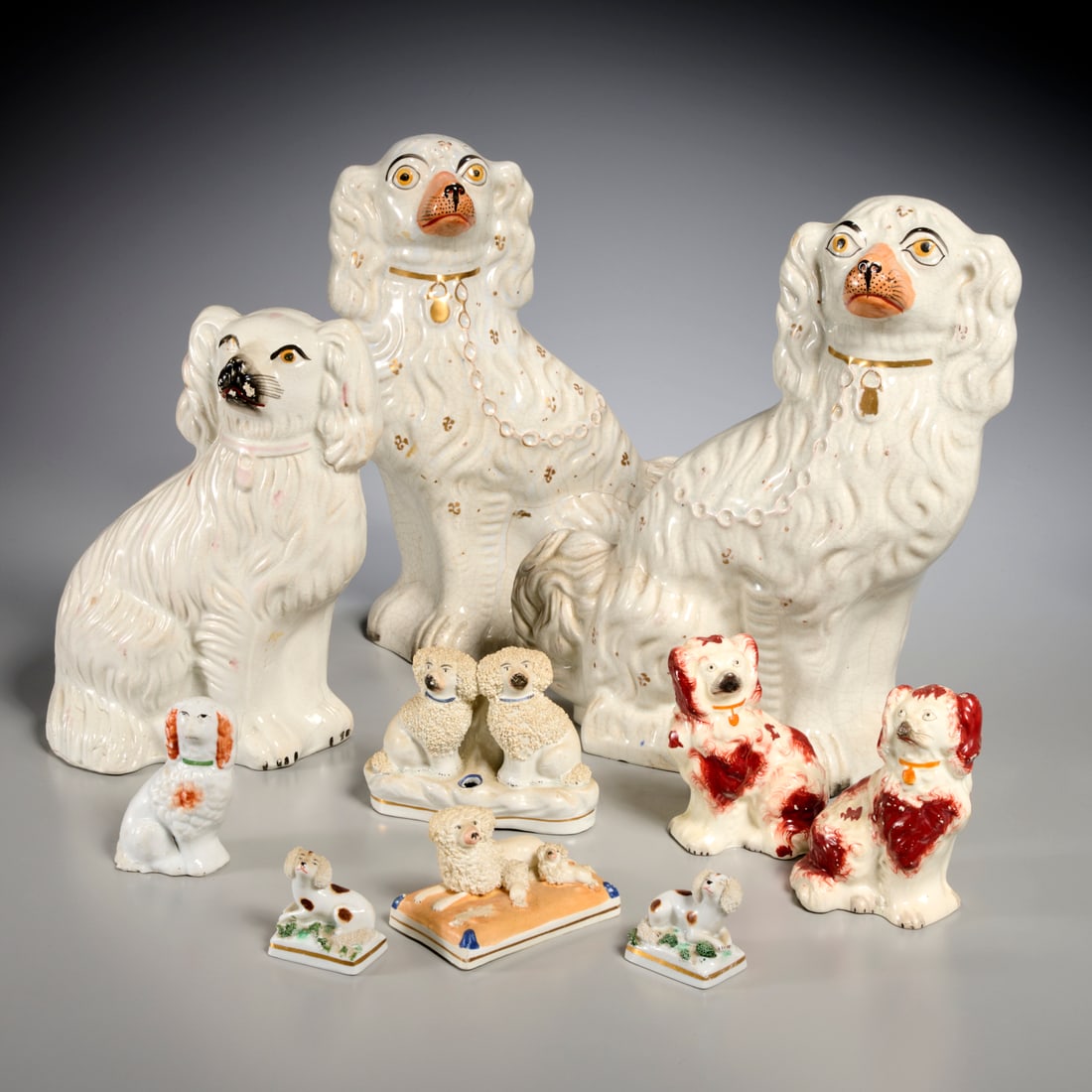 Antique Staffordshire spaniel collection: Antique Staffordshire spaniel collection, 19th/20th c., England, (10) pieces, incl. gilt decorated, rust red painted, and textured fur examples, 12.5"h x 8.5"w x 4"d (largest), 1.75"h x 2"w x 1.25"d