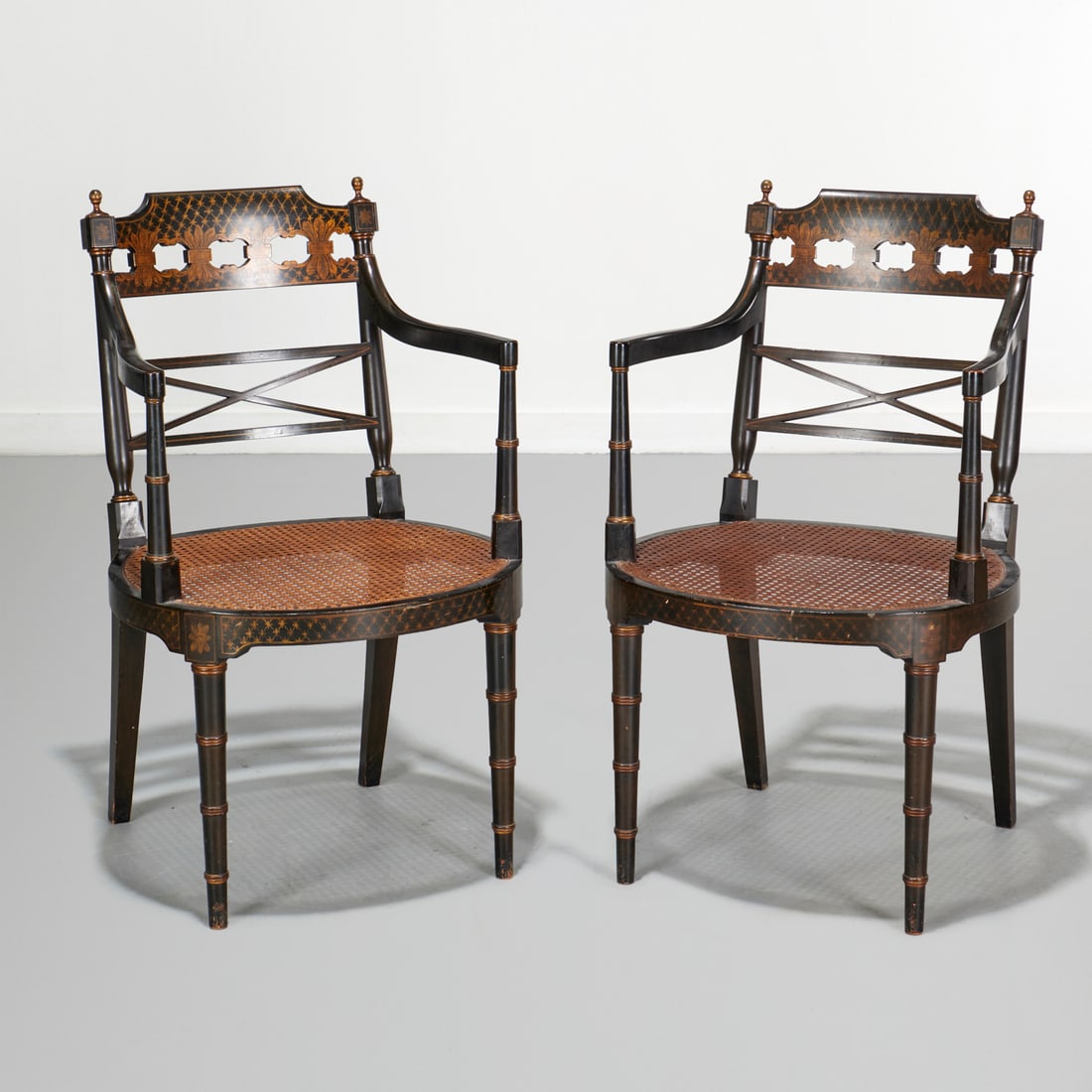 Pair Regency style caned armchairs: Pair Regency style caned armchairs, 20th c., black and gold, with caned seat, unmarked, 35"h x 21"w x 19"d