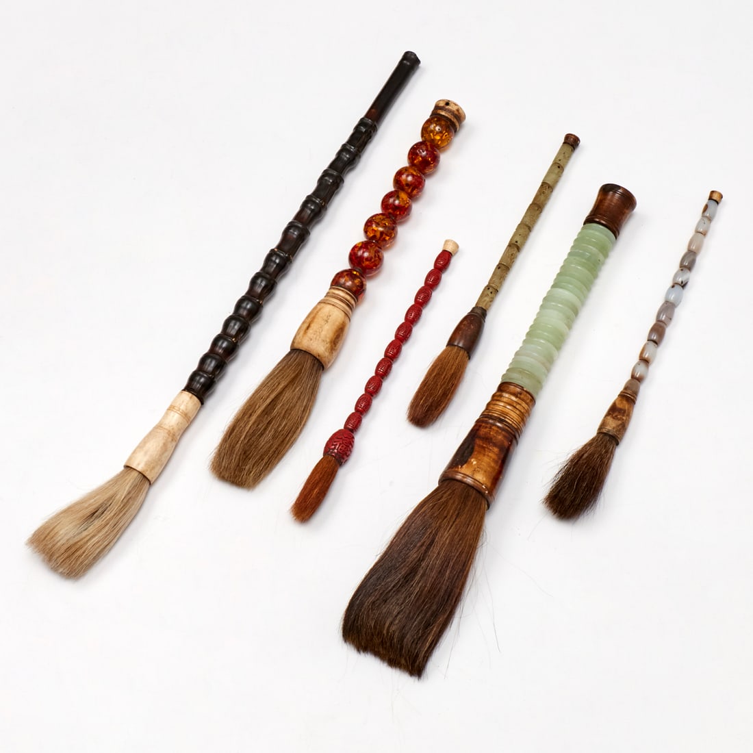 (6) antique Chinese calligraphy brushes: (6) antique Chinese calligraphy brushes, Late Qing Dynasty, (19th/20th c.), of various size and material, incl. lacquer, jade, amber, agate, and bamboo, 19"l (longest), 9.5"l (shortest) Provenance: Pr