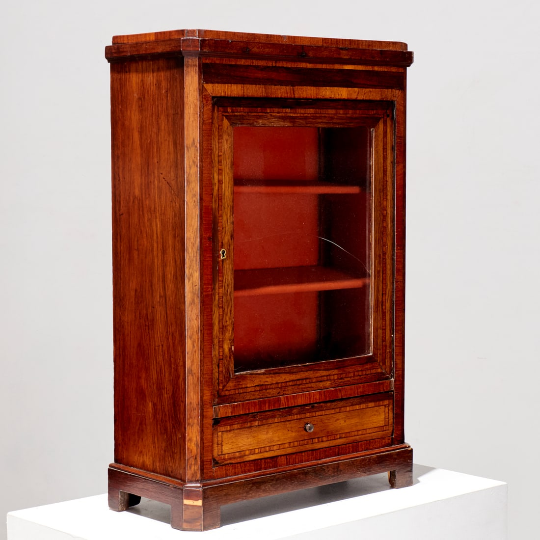 Antique inlaid rosewood curio cabinet: Antique inlaid rosewood curio cabinet, 19th c., hinged glass door opening to fixed shelves, lined with orange velvet, over single drawer, raised on short pedestal, initial and mark on back of drawer,