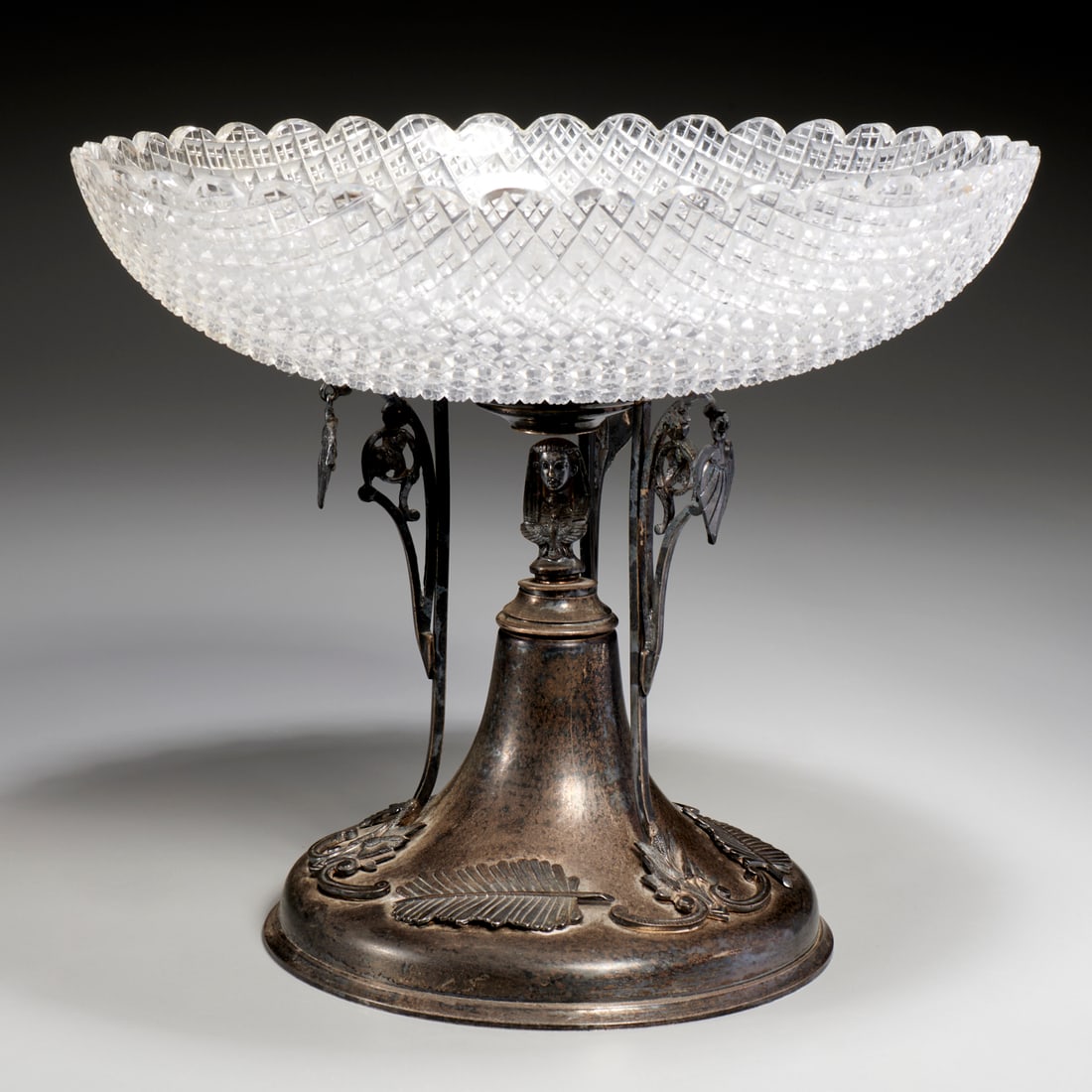 Egyptian Revival sterling and cut glass compote: Egyptian Revival sterling and cut glass compote, Late 19th c., USA, mark of Whiting , diamond cut glass bowl raised on slender supports decorated with dangling ornaments, surrounding Egyptian bust,