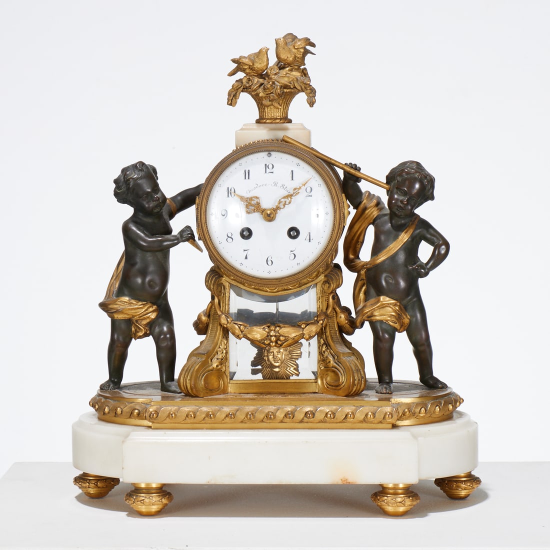Vincenti & Cie bronze and marble mantel clock: Vincenti & Cie bronze and marble mantel clock, Mid 19th c., France, patinated and gilt bronze, decorated with birds on flower basket finial, putti figures, and floral swags, on white marble base, with