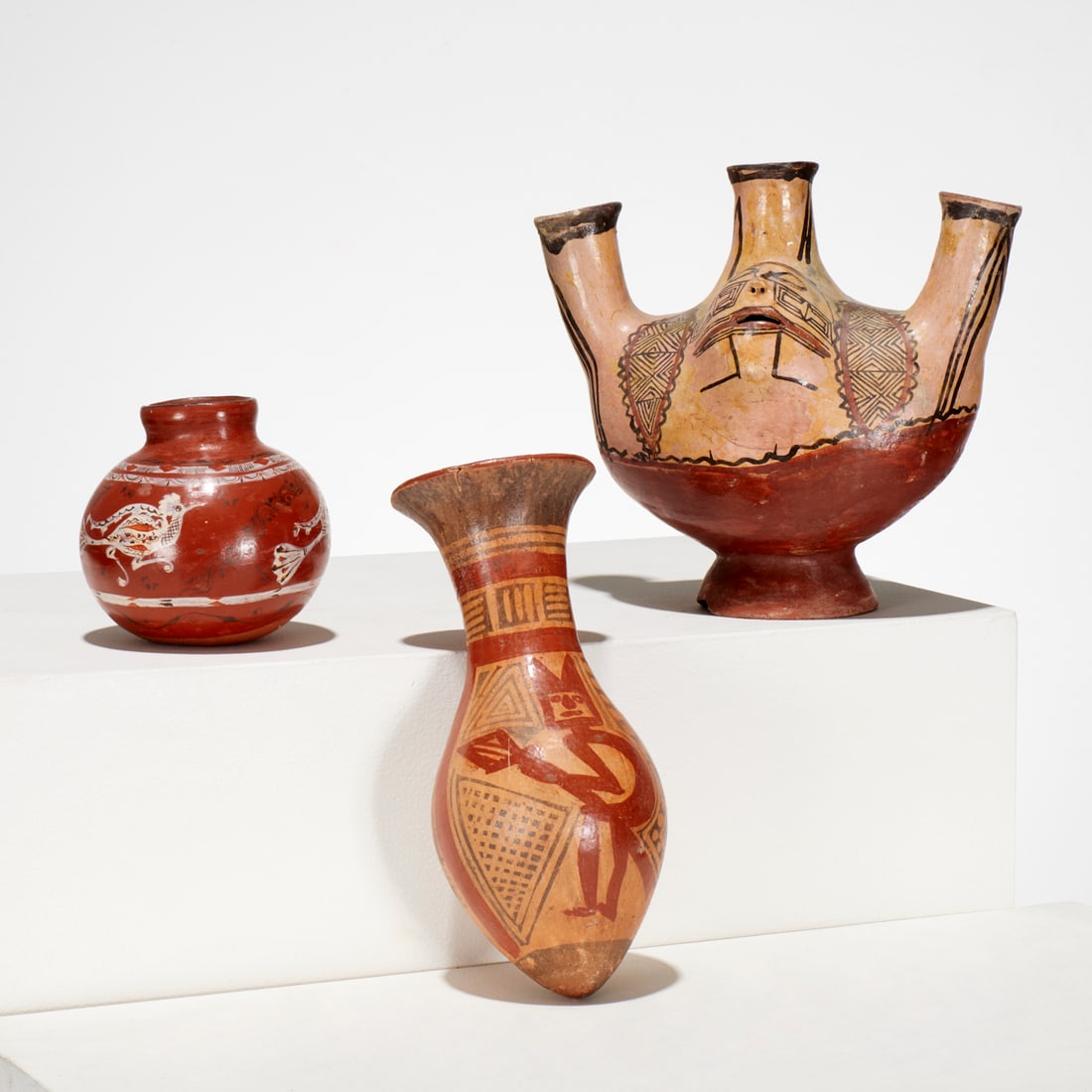 (3) Pre-Columbian and Mexican style clay vessels: (3) Pre-Columbian and Mexican style clay vessels, Incl. a Carchi-Narino bullet amphora, possibly 750-1250 CE, inventory label to interior, 10"h x 4.5"dia; and a three-spout jar with raised faces and g