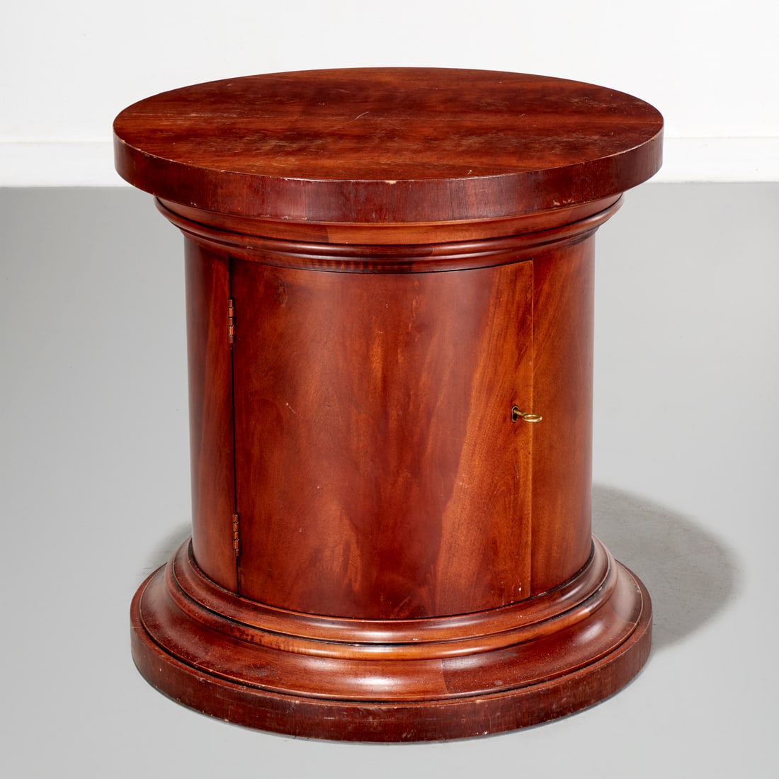 Ralph Lauren, mahogany drum side table: Ralph Lauren, mahogany drum side table, 20th c., round form, with single door and single interior shelf, metal placard label to interior, 25.5"h x 25"dia