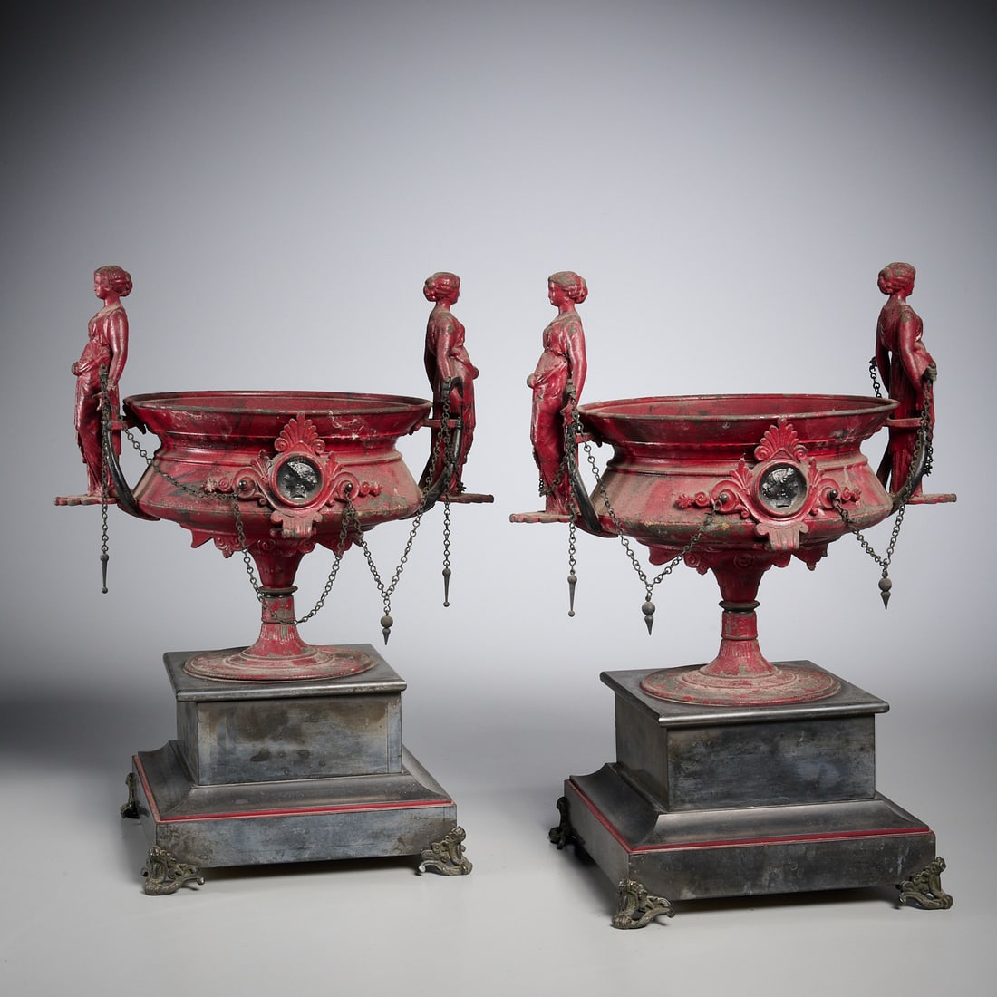 Pair Renaissance Revival garniture urns: Pair Renaissance Revival garniture urns, Late 19th c., red patinated metal urns with caryatid handles, profile medallion mounts, on stepped stone pedestal bases, 15.5"h x 12.5"w x 8.25"d Provenance: