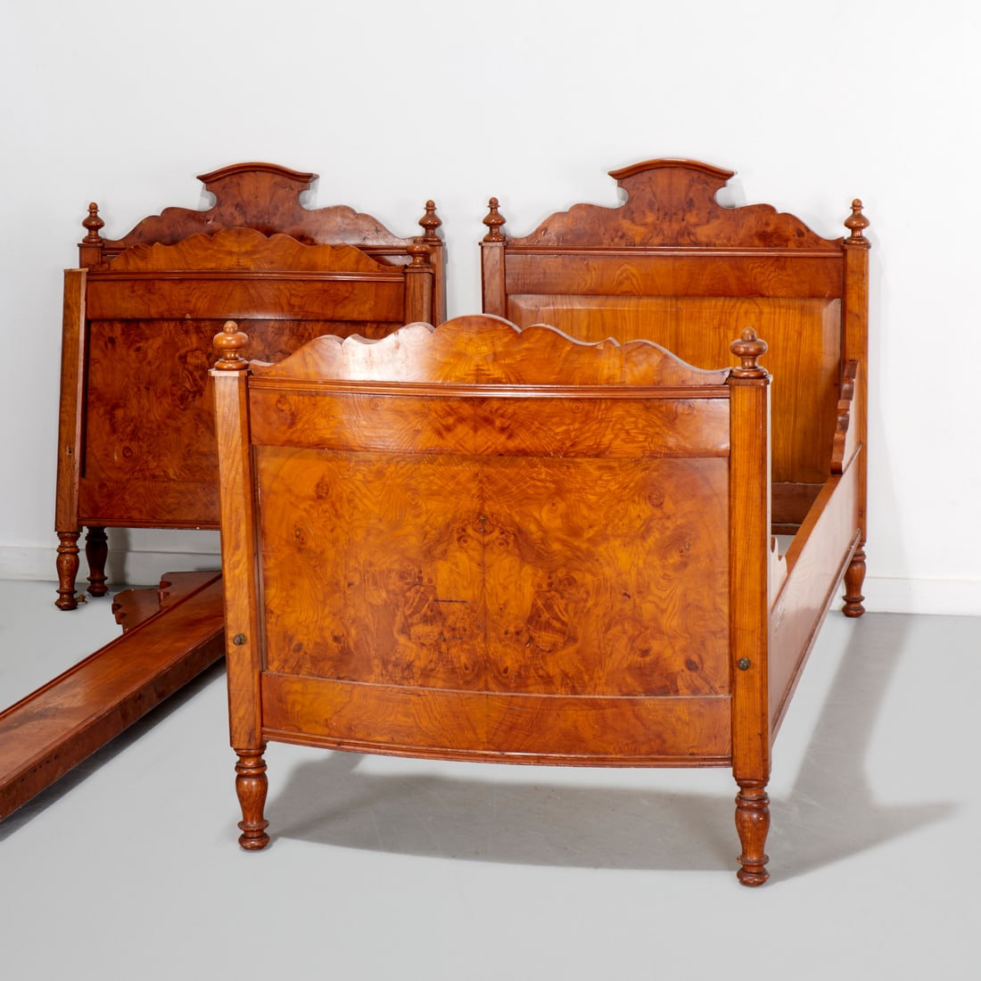 Pair Continental burl walnut daybeds: Pair Continental burl walnut daybeds, 19th/20th c., with turned finials, each 46.75"h x 83"l x 39.5"w