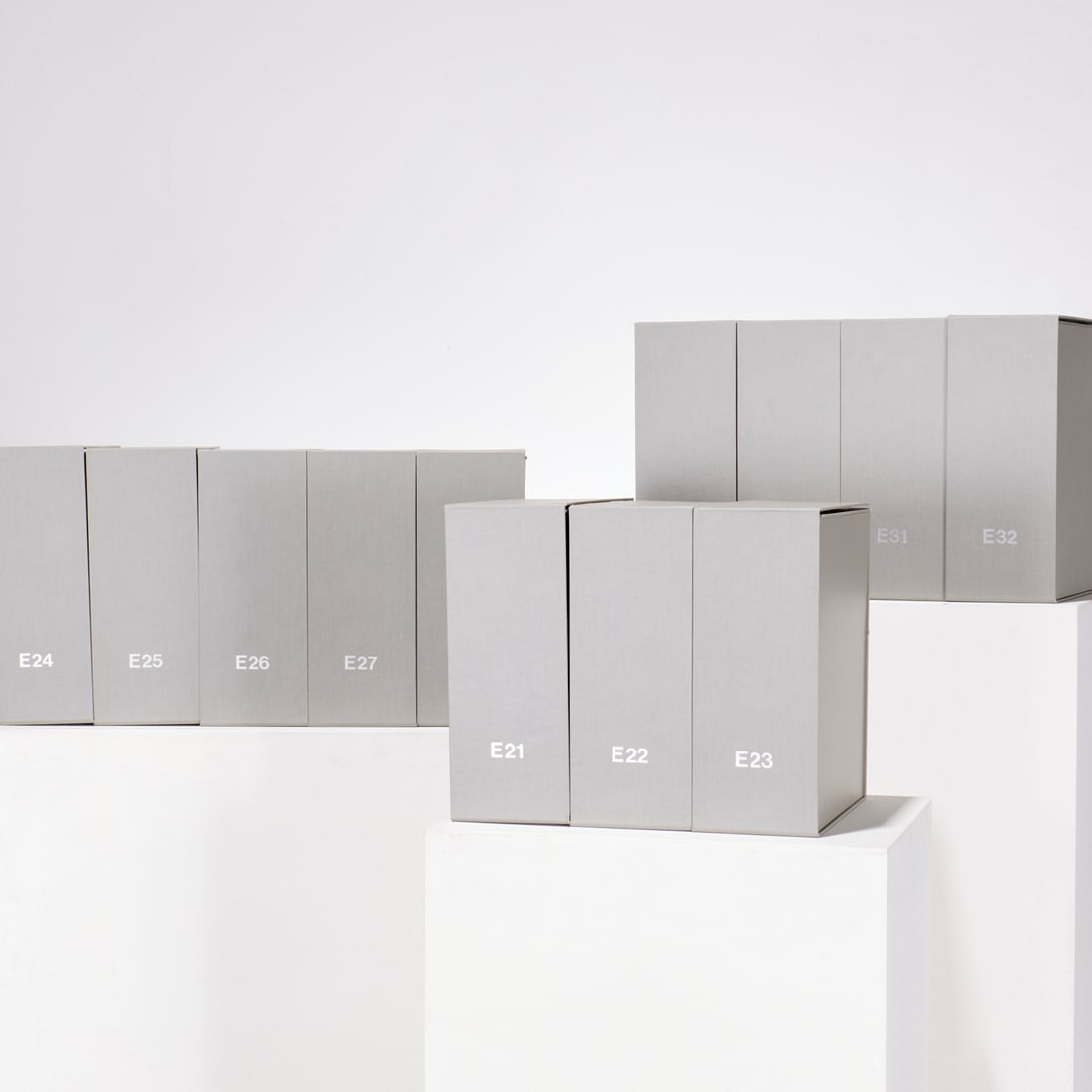 (12) Library-quality book or document boxes: (12) Library-quality book or document boxes, Covered in light grey, coated cloth, lined with white paper, two top flaps held closed with 4 Velcro buttons, one lid flap hinges down for easy access,