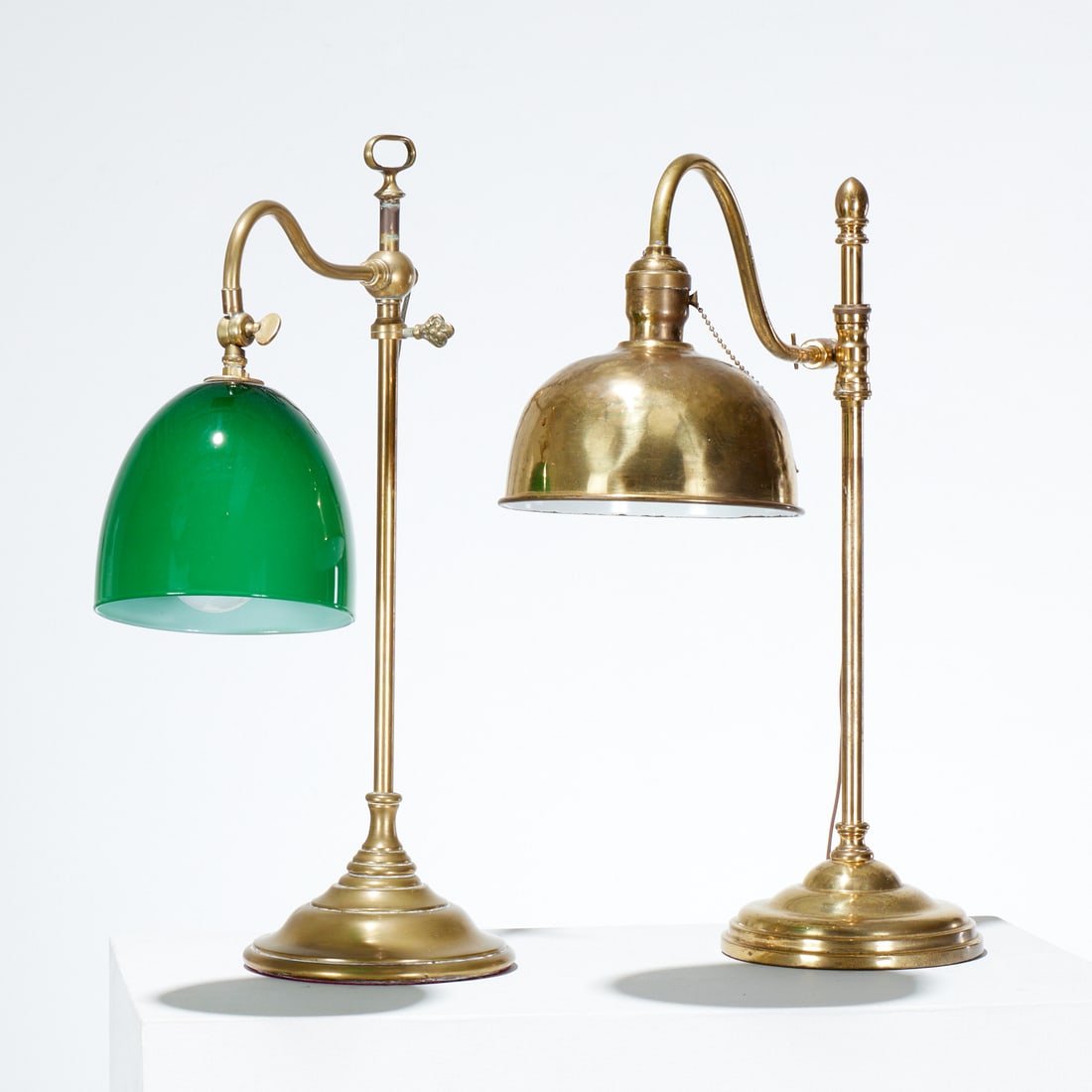 (2) Antique English brass desk lamps: (2) Antique English brass desk lamps, First quarter 20th c., one with green glass shade, 20.5"h x 6.5"dia (larger), 19.75"h x 6.5"dia (smaller)