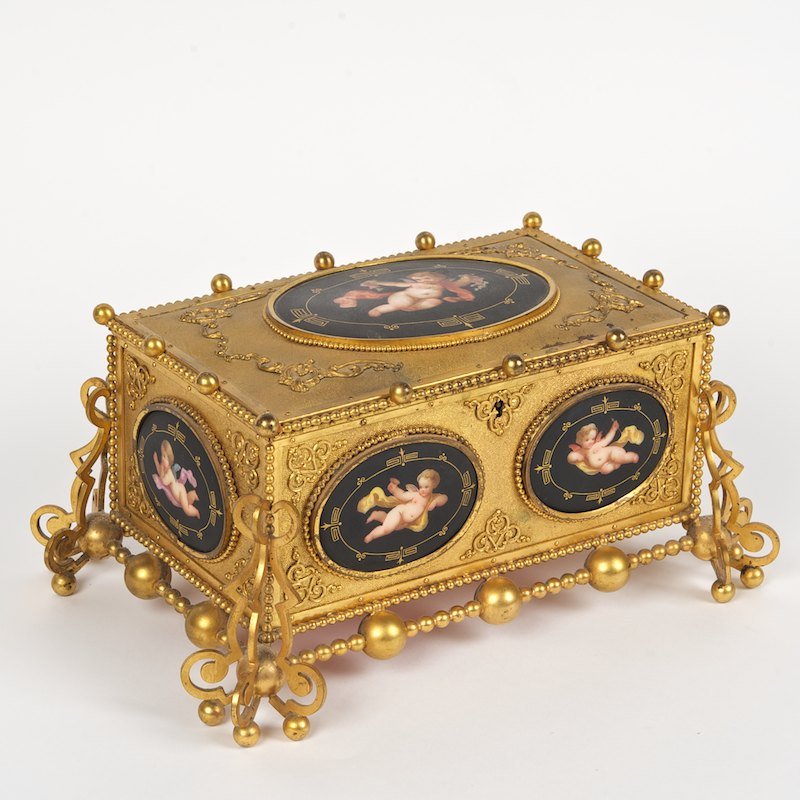 Napoleon III porcelain mounted ormolu box: Napoleon III porcelain mounted ormolu box, 19th., oval black ground putto plaques, stamped "MORFAU", 5"h x 11"l x 8"d