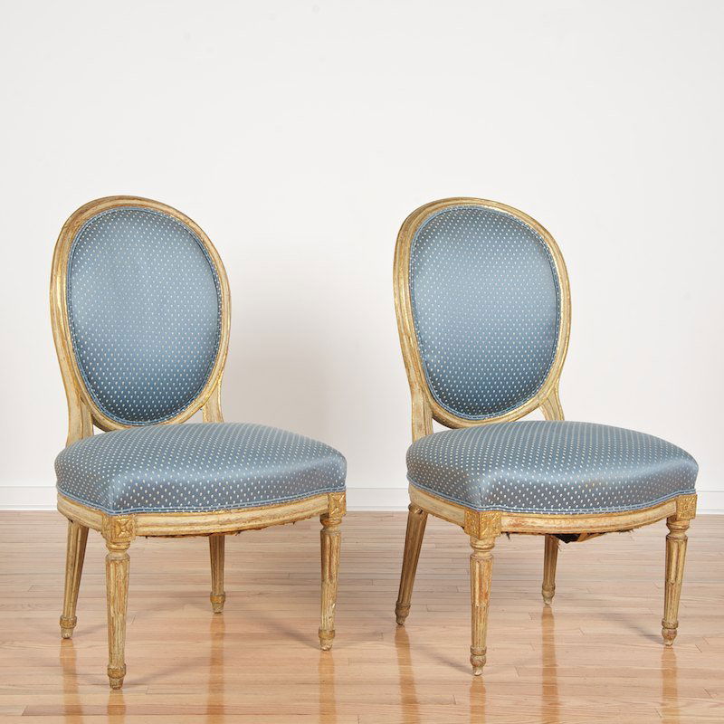Pair Louis XVI cream painted and gilt chaises: Pair Louis XVI cream painted and gilt chaises, 19th c., balloon backs, small blue print upholstery, 36"h x 21.5"w x 19"d