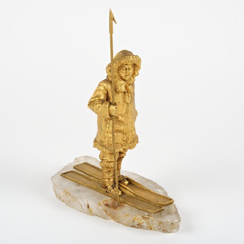 Russian gilt bronze and rock crystal model of an Eskimo: Russian gilt bronze and rock crystal model of an Eskimo, 19th/20th c., posed on skis with spear, unsigned, 9.25"h x 8"l x 4"w