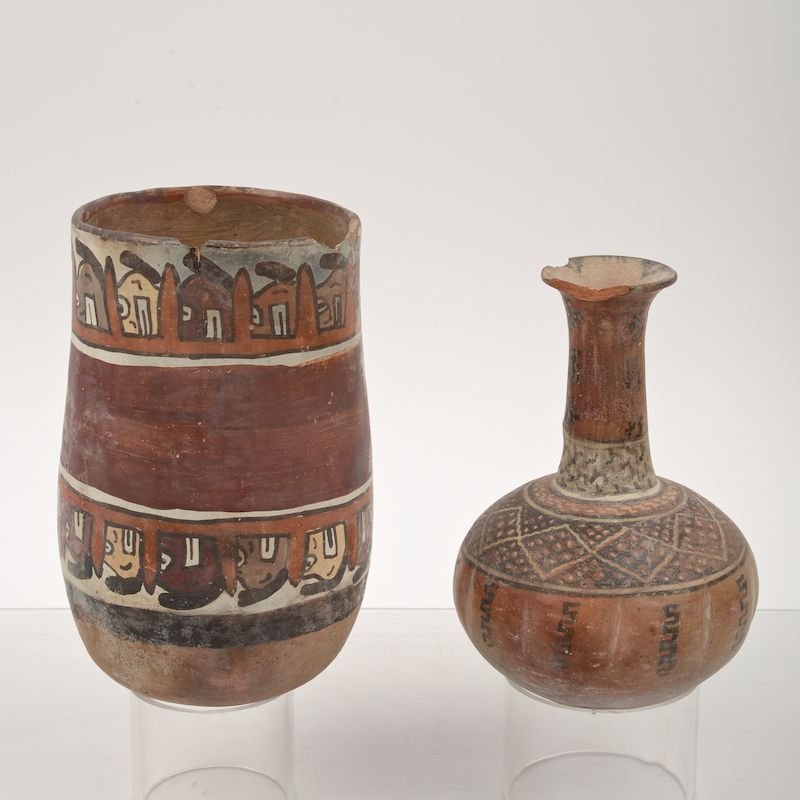 (2) Pre-Columbian painted pottery vessels: (2) Pre-Columbian painted pottery vessels, Possibly Nazca, incl. a kero and a bottle/ewer, line and face decoration, old painted accession nos. "L.1860-177" and "L.1860-149", 7.5"h x 4.75"dia. (kero)
