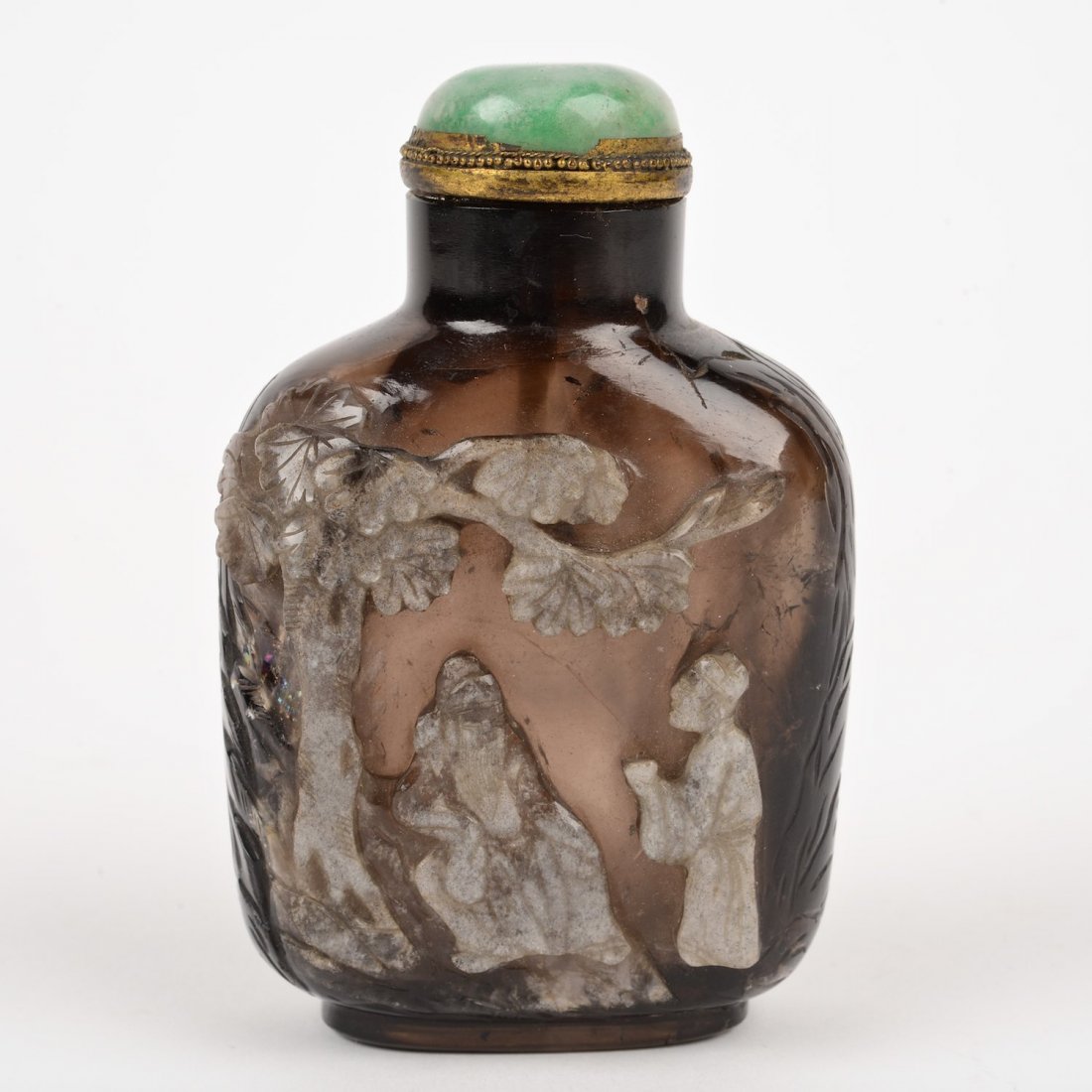 Large Chinese carved smoky quartz snuff bottle: Large Chinese carved smoky quartz snuff bottle, Qing Dynasty, well hollowed, with gilt metal rimmed green jade cap, 4"h x 2.5"w x 1.5"d Provenance: the Estate of Dr. Marc Bernheim, NY