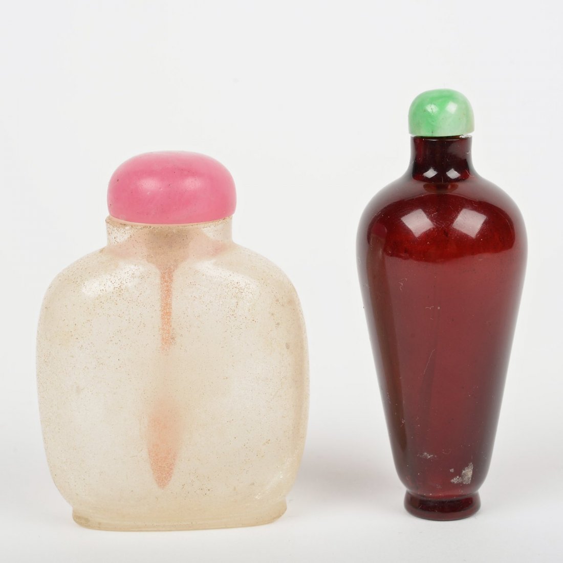 (2) Chinese Peking glass snuff bottles: (2) Chinese Peking glass snuff bottles, 19th/20th c., clear crackle and deep red with jade cap, 2.5"h x 1.75"w and 3"h x 1" dia.