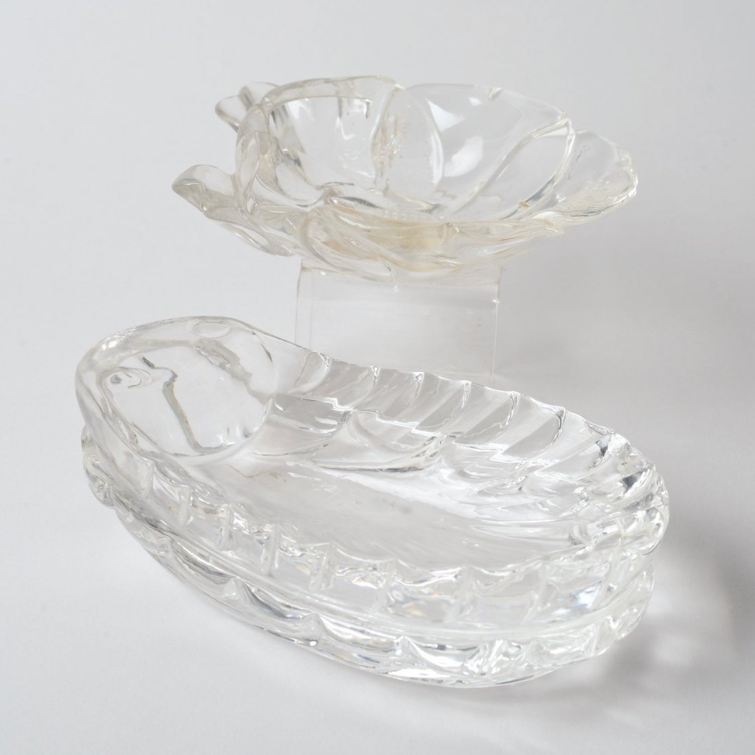 (2) Chinese carved rock crystal coupes: (2) Chinese carved rock crystal coupes, 19th/20th c., incl. scallop shell and floral blossom, 1.75"h x 5.75"l x 3.5"w (shell), 1.25"h x 4.25"dia. (flower) Provenance: the Estate of Edgar M. Bronfman, 
