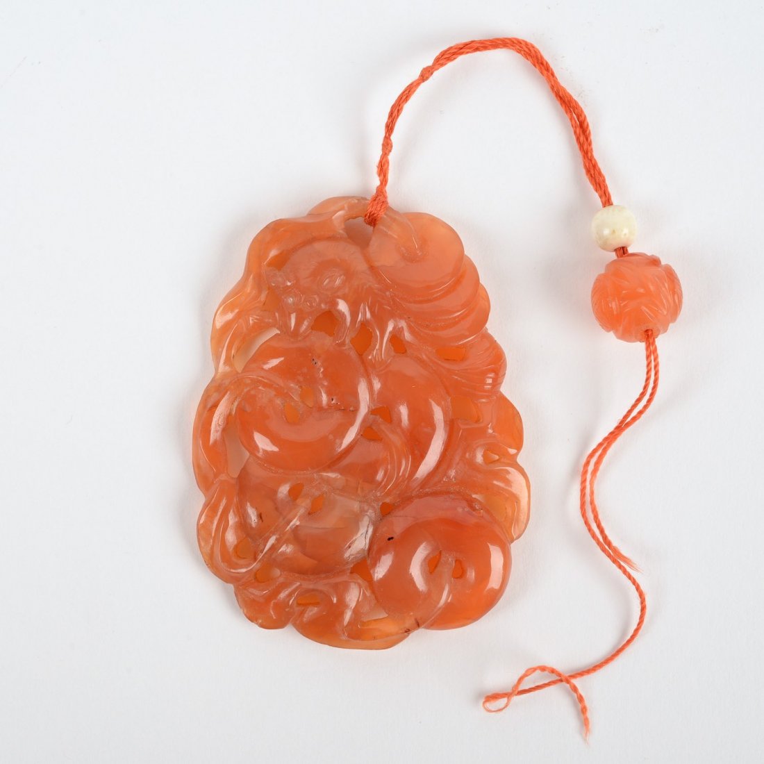 Chinese orange hardstone or jade pendant: Chinese orange hardstone or jade pendant, 19th/20th c., coin and squirrel design, 2.75"h x 2"w