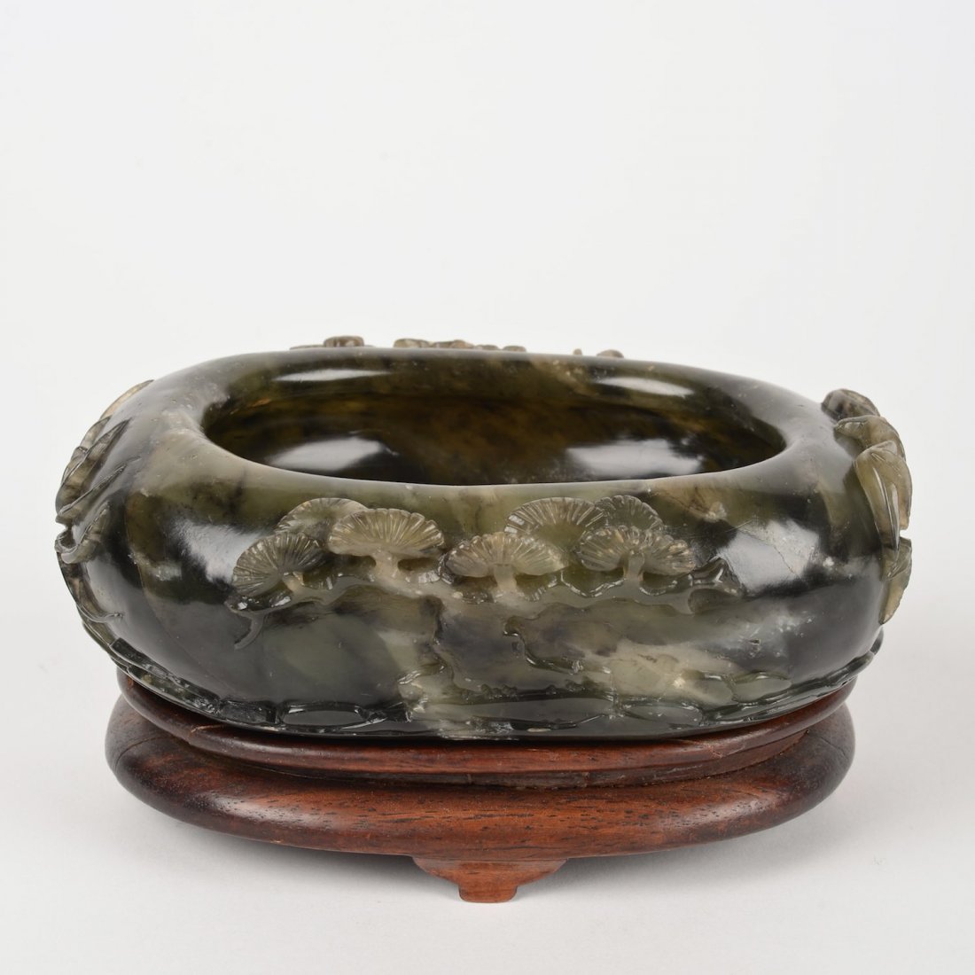 Chinese carved green soapstone brush washer: Chinese carved green soapstone brush washer, 19th/20th c., bamboo and prunus decoration, on hardwood stand, 2"h x 5.5"l x 4.25"d (excl. stand)