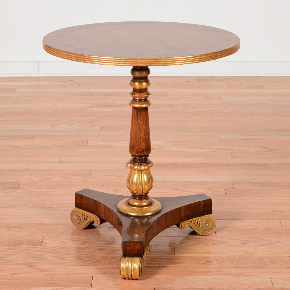 Regency style parcel gilt rosewood occasional table: Regency style parcel gilt rosewood occasional table, 19th/20th c., round top, bronze mounted base, 22"h x 19.5"dia. Provenance: from the Estate of Edgar M. Bronfman, New York, NY