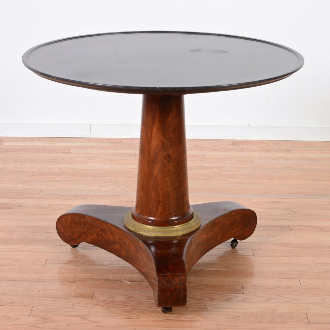 Empire gilt bronze mounted mahogany center table: Empire gilt bronze mounted mahogany center table, 19th c., circular dished black marble top, 28.5"h x 34.5"dia.