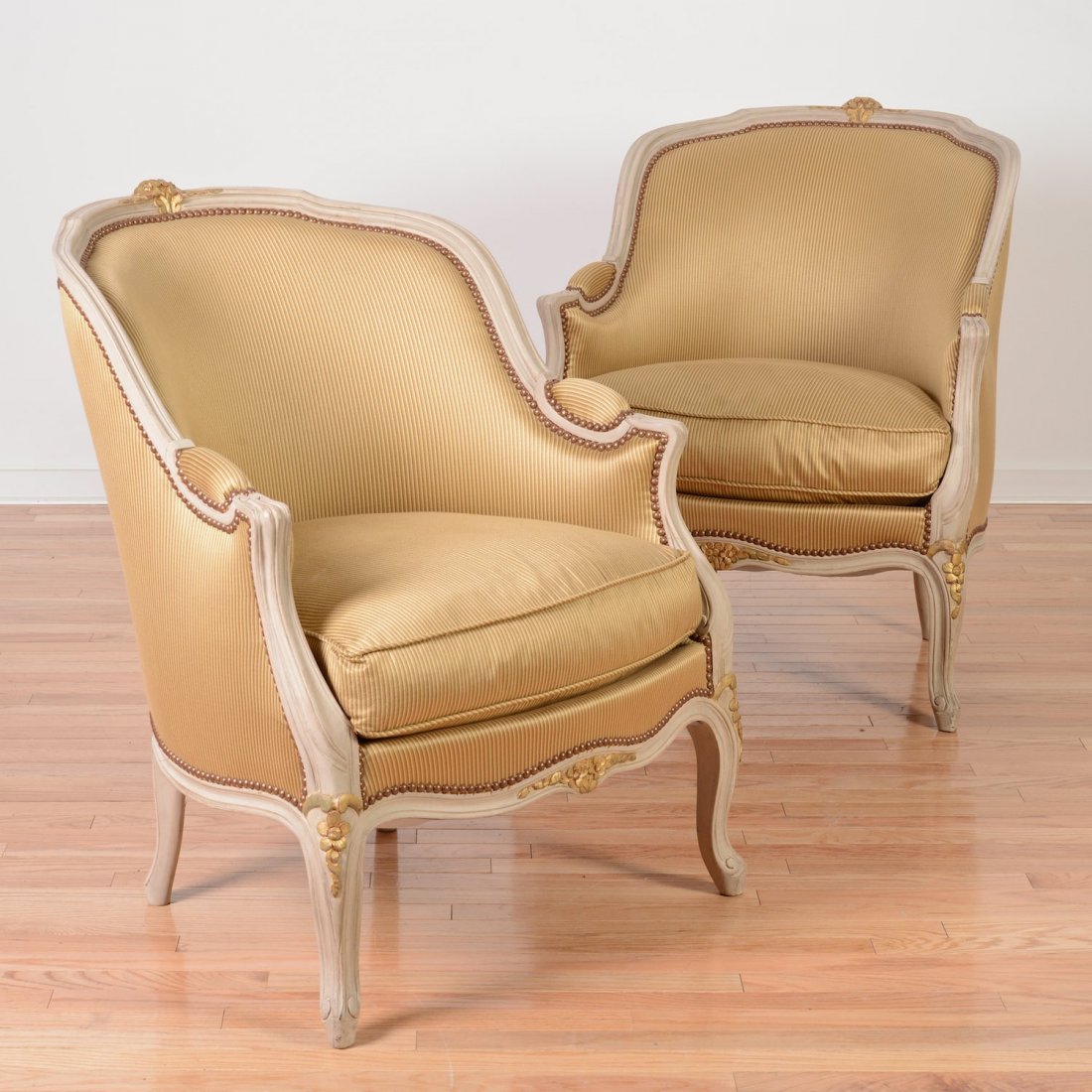 Pair Louis XV style gray painted bergeres: Pair Louis XV style gray painted bergeres, 20th c., parcel gilt carving, pin striped silk upholstery, 34.5"h x 28.5"w x 30"d