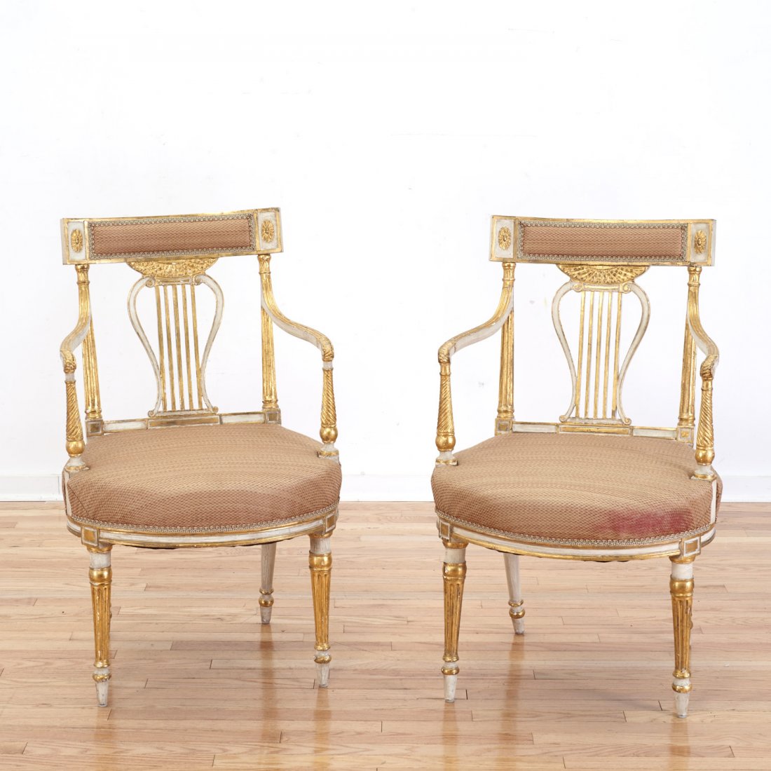 Pair Louis XVI parcel gilt lyre-back armchairs: Pair Louis XVI parcel gilt lyre-back armchairs, 19th c., white painted, upholstered seat and crest rail, fluted tapered legs, 36"h x 21"w x 19"d