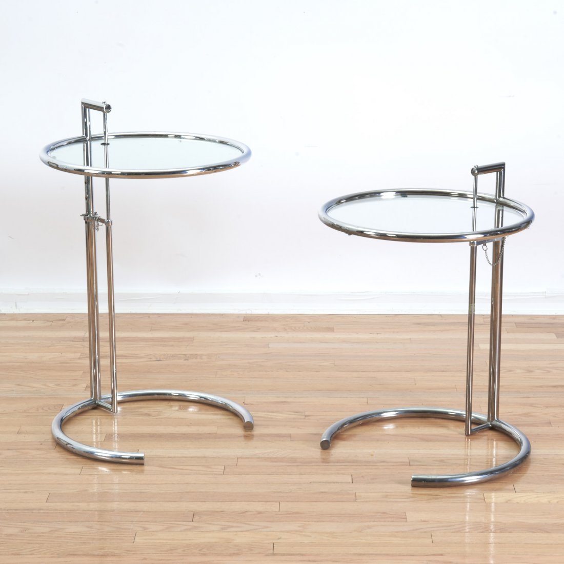 Pair Eileen Gray e-1027 adjustable side tables: Pair Eileen Gray e-1027 adjustable side tables, Circa 1970', designed 1927, chromed tubular steel with glass top, one example marked "B51 25773", 24"h x 20"dia., 40"h (highest) Provenance: Property Fr