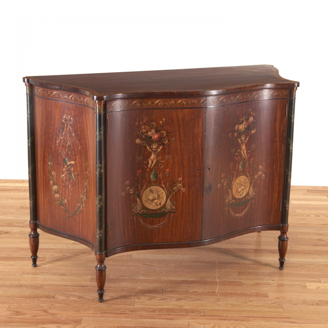 Edwardian paint decorated serpentine cabinet: Edwardian paint decorated serpentine cabinet, 19th/20th c., decorated in the manner of Robert Adam, interior shelves, 36"h x 51.5"w x 23"d