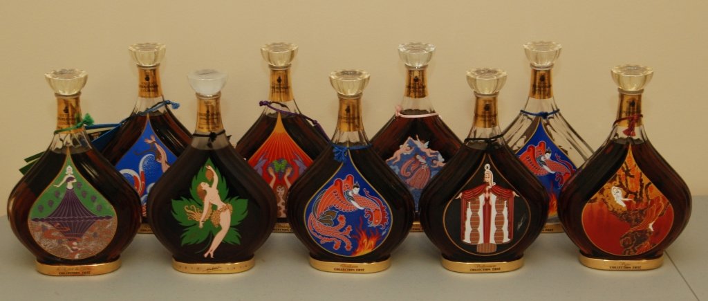 ROMAN DE TIRTOFF ERTE COURVOISIER COLLECTION: ROMAN DE TIRTOFF ERTE COURVOISIER COLLECTION Collection of Eight Erte Cognac Bottles Unopened and Paperwork. Each with Different Labels. 10" Tall, Each Bottle Weighs 1600gms. No Box. Collection Dates