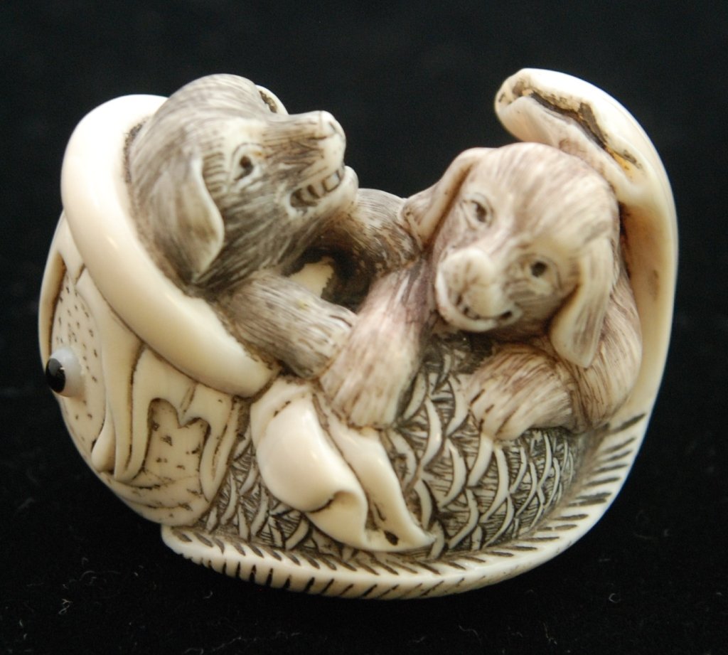 SUPER CHINESE IVORY PUPPY DOG NETSUKE: SUPER CHINESE IVORY PUPPY DOG NETSUKE Measures Approximately 2" in Diameter. Signed to Base, Depicting Two Puppies in a Fish. Circa Mid 20th Century. 49gms Wild life Endangered Species Act laws must b