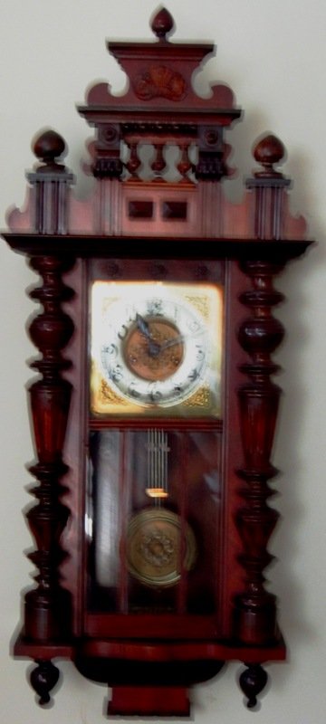 ANTIQUE CONTINENTAL CARVED WALL CLOCK: Late 19th Century. with Tin Face. Comes with Original Pendulum and Key. Beautifully Carved Case. Probably Walnut. Measures Approximately 44" Tall by 16" wide.