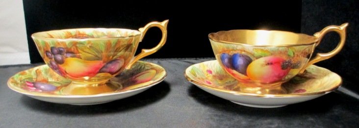 BONE CHINA ANSLEY ENGLAND PAIR OF CUP AND SAUCER: Gold Plated Ansley Bone China Pair of Cups, and Saucers. Colorful design of Peaches, Grapes, and Plums. Each Cup Measures 2 1/4" High by 5" Wide Saucer Measures 5 3/4" Wide.