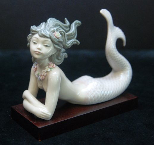 RETIRED LLADRO MERMAID "FANTASY" #1414 Retired Lladro: RETIRED LLADRO MERMAID "FANTASY" #1414 Retired Lladro porcelain figurine of a mermaid. Model #1414. Title: Fantasy. 4.5".Tall by 6" Wide. Weights 329.20 Grams. Comes on Wood Base.