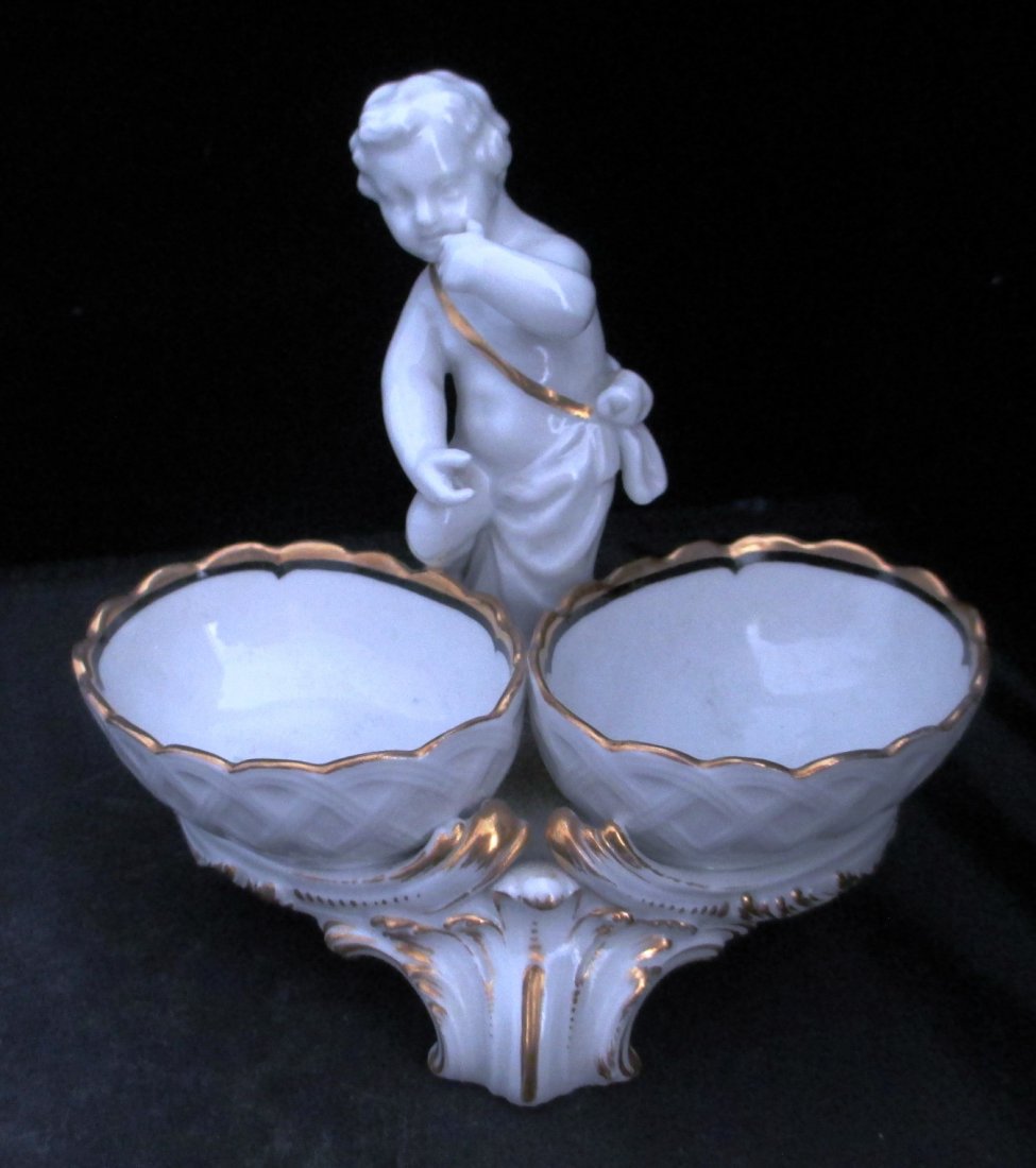 KPM PORCELAIN FIGURAL CANDY DISH KPM porcelain figural: KPM PORCELAIN FIGURAL CANDY DISH KPM porcelain figural candy dish features a putti wearing a gold wrap, and 2 decorative bowls. Lots of gilt enamel. Measures: 5" Tall X 5" Wide
