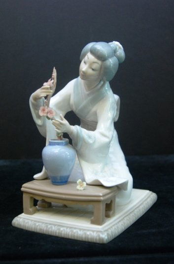LLADRO GEISHA WOMAN WITH VASE FULL OF FLOWERS Lladro: LLADRO GEISHA WOMAN WITH VASE FULL OF FLOWERS Lladro figurine of geisha women kneeling tending to vase of flowers. Measures 8.5" Tall by 6" Long. Weights 1207.40 Grams