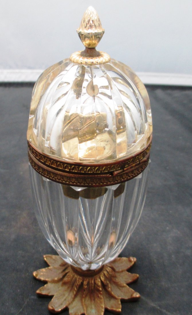 ANTIQUE CRYSTAL AND BRASS CIGARETTE LIGHTER: ANTIQUE CRYSTAL AND BRASS CIGARETTE LIGHTER Shaped in the manner of Faberge Egg. Floral Base . Measures 6 1/2" Tall