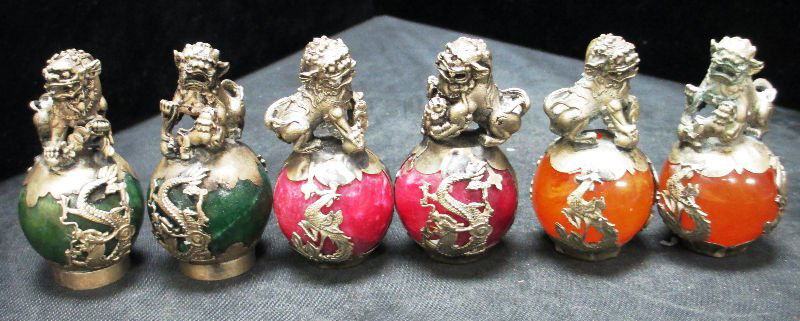 6 TIBETAN SILVER AND PORCELAIN FOO DOG STATUES: 6 TIBETAN SILVER AND PORCELAIN FOO DOG STATUES 2 Pink Porcelain with Silver measures 2 3/4" Tall, 2 Dark Green Porcelain with Silver Foo Dogs measures 2 3/4" Tall, and 2 Orange Porcelain with Silver F