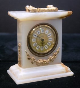 ONYX AND BRASS WEST GERMAN ALARM CLOCK: Onyx and Brass West German Carriage Alarm Clock. Brass Face with Porcelain Numerals. Windup Movement. Measures 5" Tall by 4.5" Long