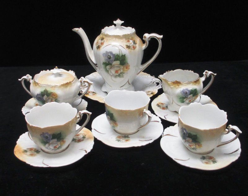 ANTIQUE FLORAL PORCELAIN TEA SET: This Tea Set is at least 100 Years old includes 3 Cups with Saucers, Tea Pot with Tray, Creamer with Tray, and Sugar Bowl with Tray.