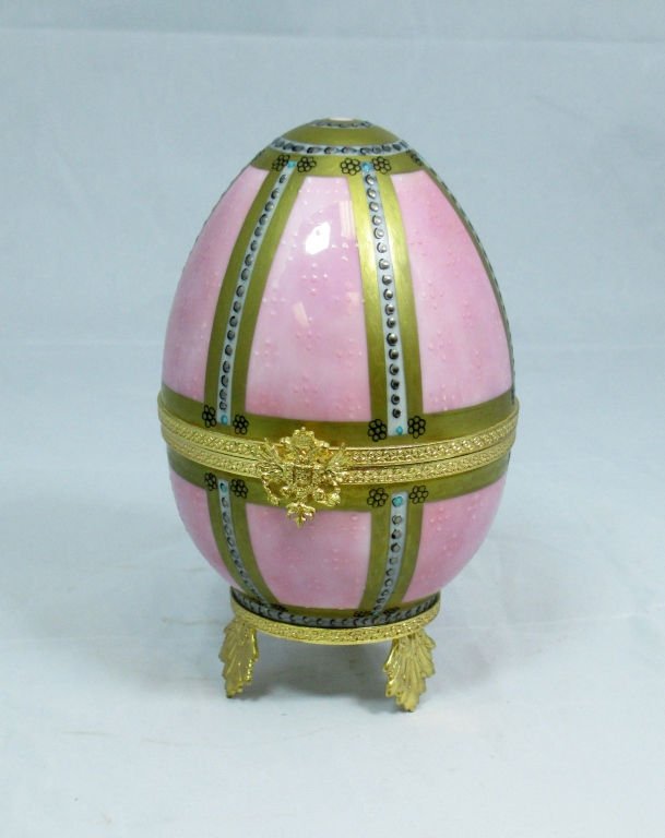 LIMODGES FABERGE IMPERIAL DANISH PALACE EGG 1895: A Limoges porcelain egg decorated in pink and 24k gold, Signed on underside "Peint Main A.F. Limoges France Faberge Imperial Danish Palace Egg 1895". Raised on gilt leaf tripod base. In very good cond