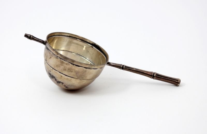 TIFFANY BAMBOO PATTERN STERLING ROLLOVER JIGGER: An elegant sterling silver rollover jigger in Tiffany & Co.'s highly desirable 1961 "Bamboo" pattern. The jigger is designed so the stems on either side of the bowl rest on the rim of cocktail shaker 