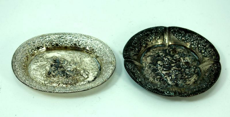 2 ANTIQUE STERLING SILVER TRAYS IN DEEP RELIEF: 1 Oval Tray 1 Round Tray. Combined Weight 3.45 Troy Ounces