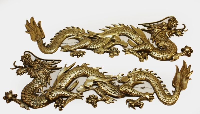 PAIR OF CHINESE GILT BRASS DRAGON WALL MOUNTS: A pair of Chinese crafted cast and gilded brass wall ornaments depicting dragons. Circa Republic period or later. Each measures approx. 15" height x 41" length.