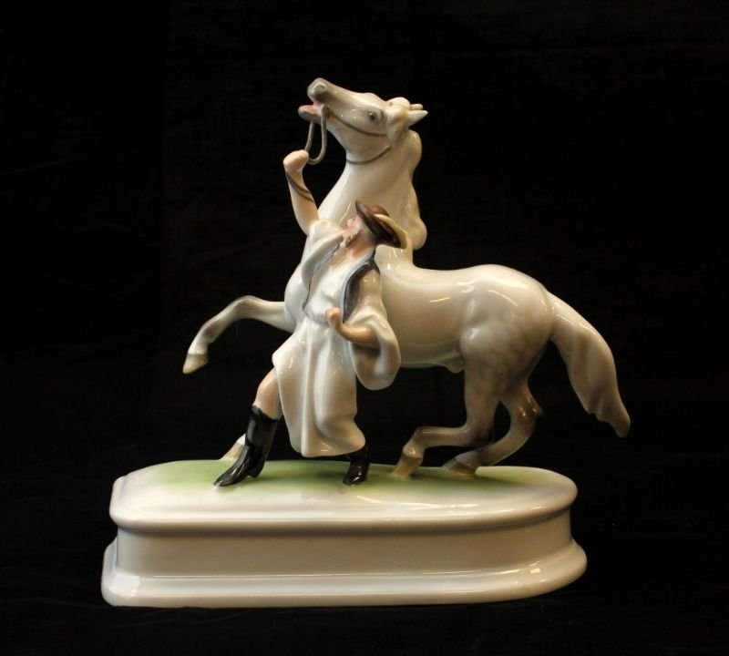 HEREND HUNGARIAN GROUP PORCELAIN OF MAN & HORSE: Herend Hungarian porcelain group sculpture depicting a horse and trainer. Bottom holds blue Herend marks with impressed HEREND and numbered 5588. Measures 8" height x 8 1/2" length.