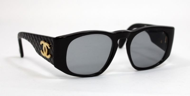 CHANEL BLACK MONOGRAM SUNGLASSES 0003 00: Chanel Paris designer sunglasses crafted of plastic with gold tone metal applique crossed C monogram design. Style number 0003 00. Circa 1990's. Includes Original box. Glasses measure 5 3/8" width x 5