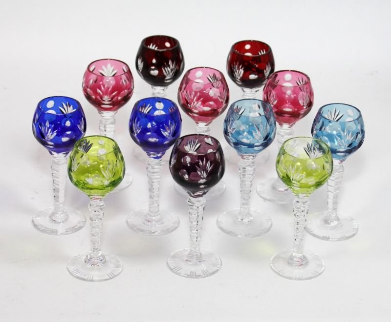 12 BOHEMIAN CRYSTAL STEMMED CORDIAL GLASSES: A set of 12 Bohemian cut and colored crystal cordial glasses. Set includes the following colors: 2 ruby, 3 cranberry, 2 cobalt, 2 emerald, 2 light blue and 1 violet.