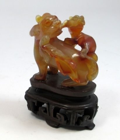 CHINESE CARVED CARNELIAN FOO LION GROUP SCULPTURE: Chinese hand carved carnelian agate group sculpture depicting adult foo lion with young. Includes fitted wooden base. Measures 2 1/4" height + 1 1/4" base height. Total weight of 99 grams.