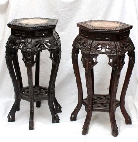 Pr EARLY CHINESE CARVED TEAKWOOD FLORAL PEDESTALS: A pair of old Chinese hand crafted teakwood marble top pedestal end tables. Each having a relief floral design throughout with hexagonal form. Has six feet with stretcher. Circa late Qing to Republic 