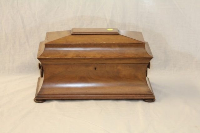 ANTIQUE ENGLISH TEA CADDY CASKET FORM: TEA CADDY - English Regency Caddy in casket form wood ring drop handles, bun feet, having intact interior, with two hinged top compartments flanking glass mixing bowl. Measures 16" Long x 9" Wide x 9"